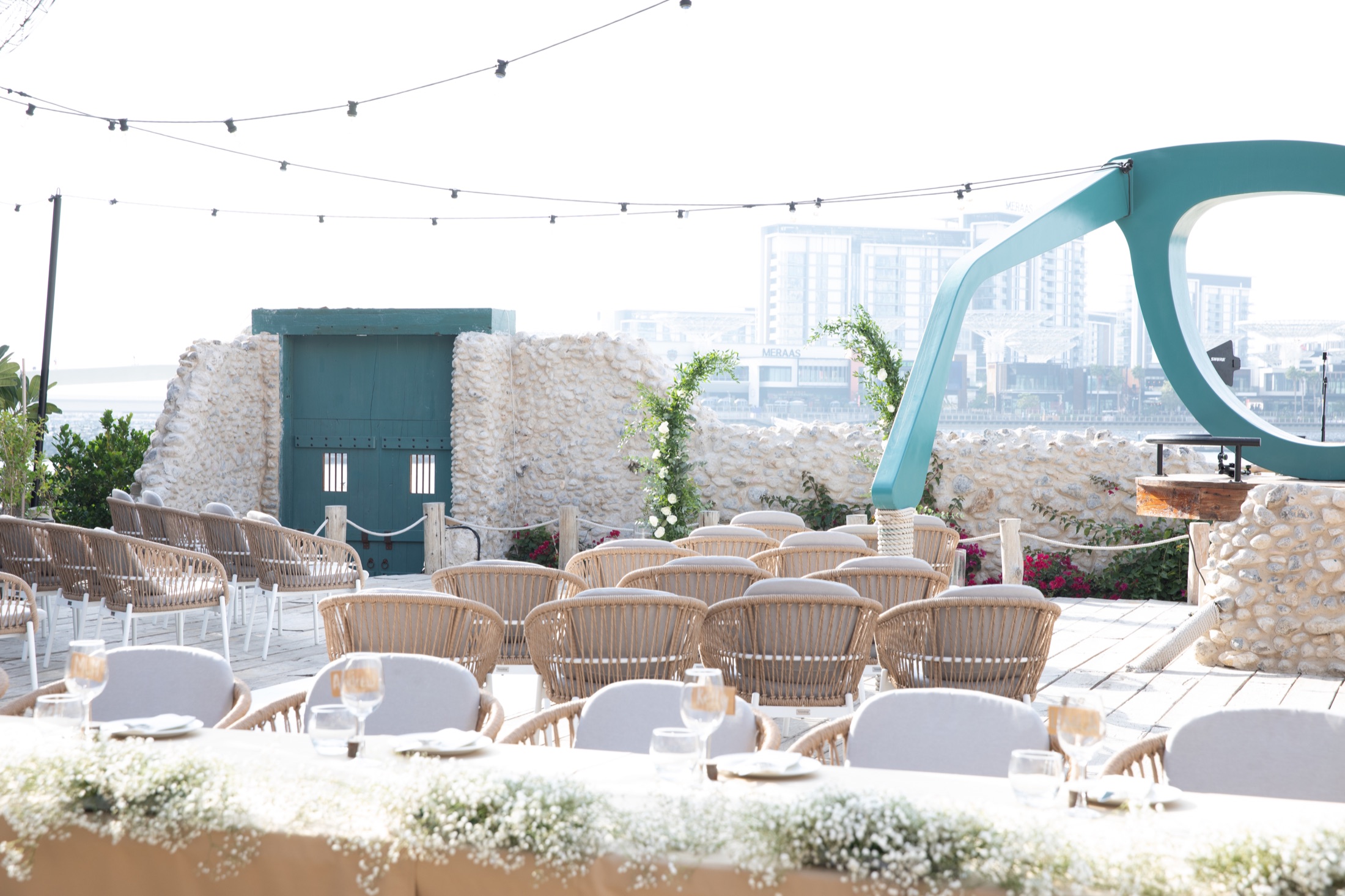 Waterfront wedding set-up with sculptural floral styling